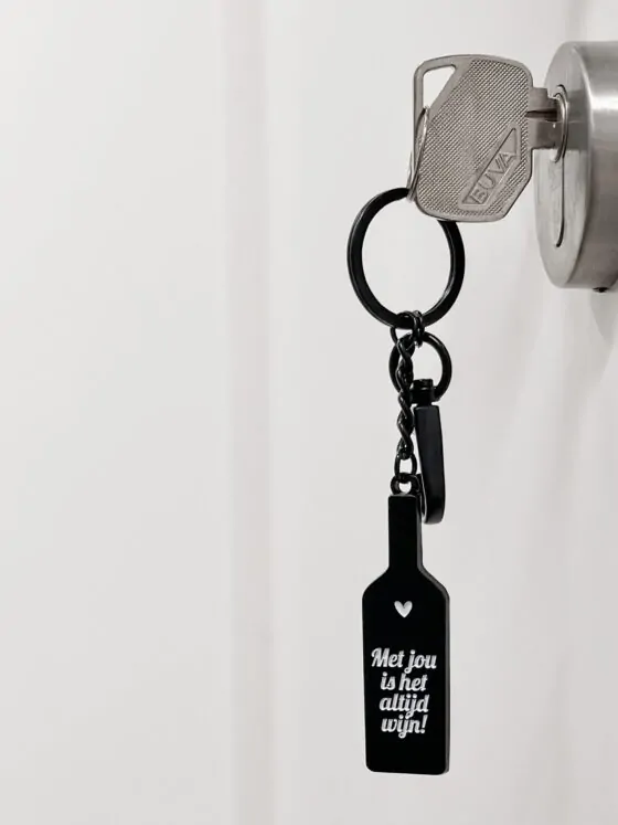 Sleutelhanger in de vorm van een wijnfles. Mat zwart metaal, ca. 11 cm. Perfect cadeau voor wijnliefhebbers!